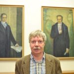 Rheinberger poses in front of the portraits of the Humboldt brothers