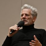 Pauls speaks into the microphone