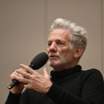 Pauls speaks into the microphone