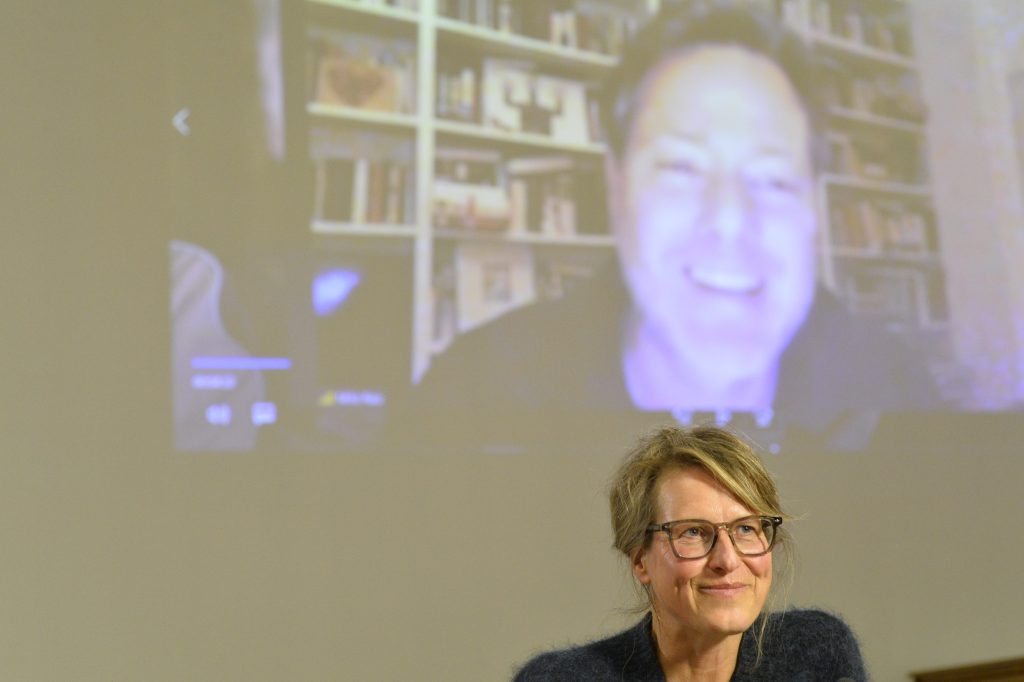 Rau speaks via Zoom connection, with Krauthausen in foreground
