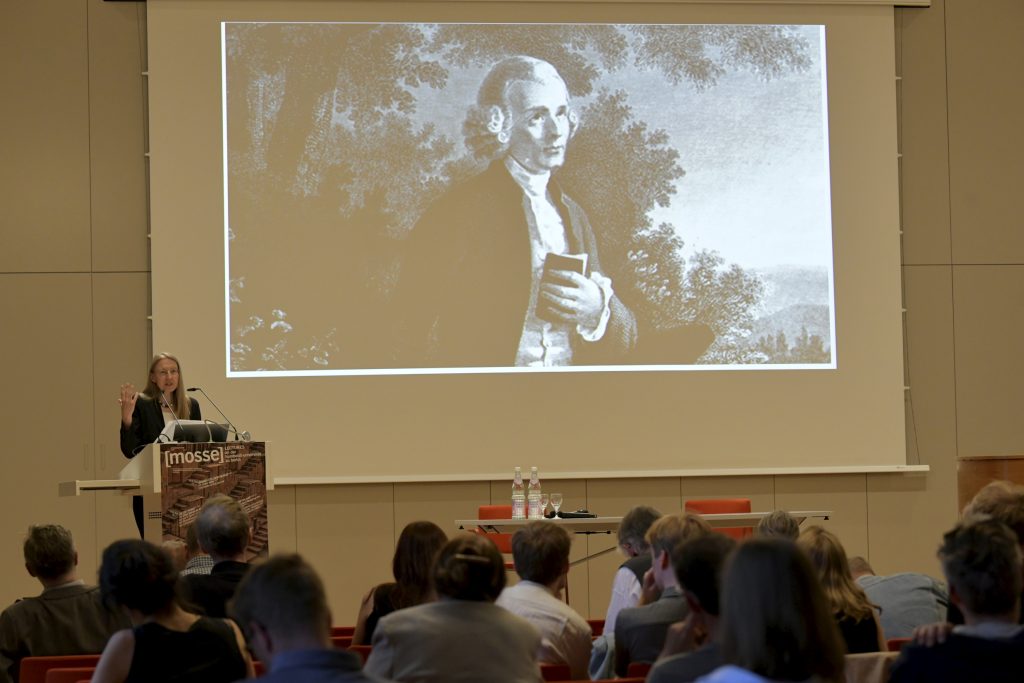 Auer speaks in front of slide