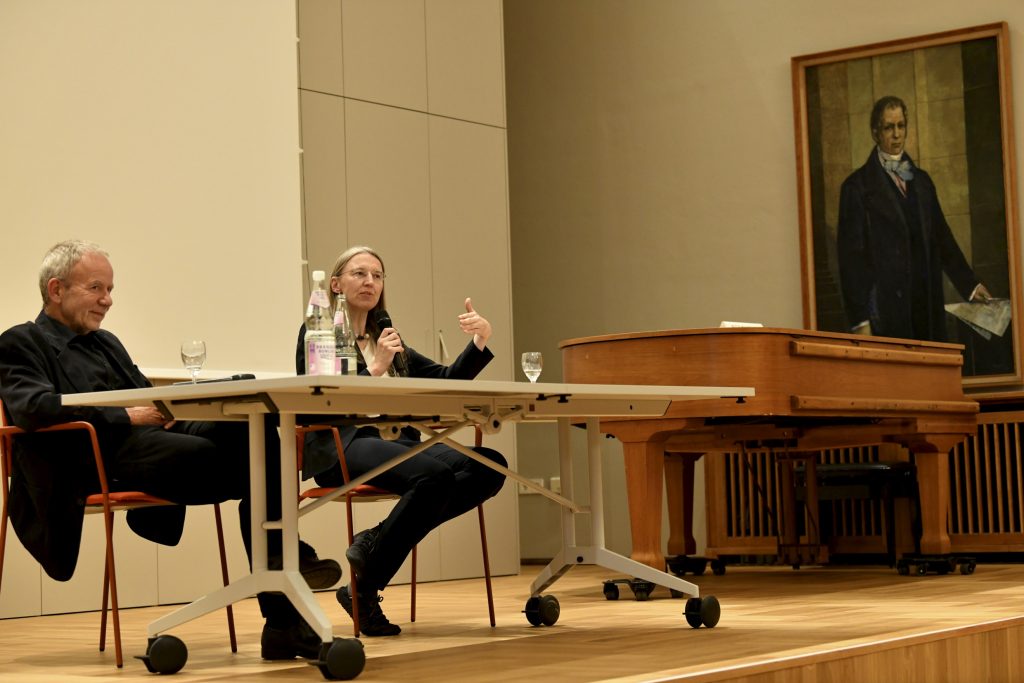 Marietta Auer speaks next to Michael Kämper-van den Boogaart