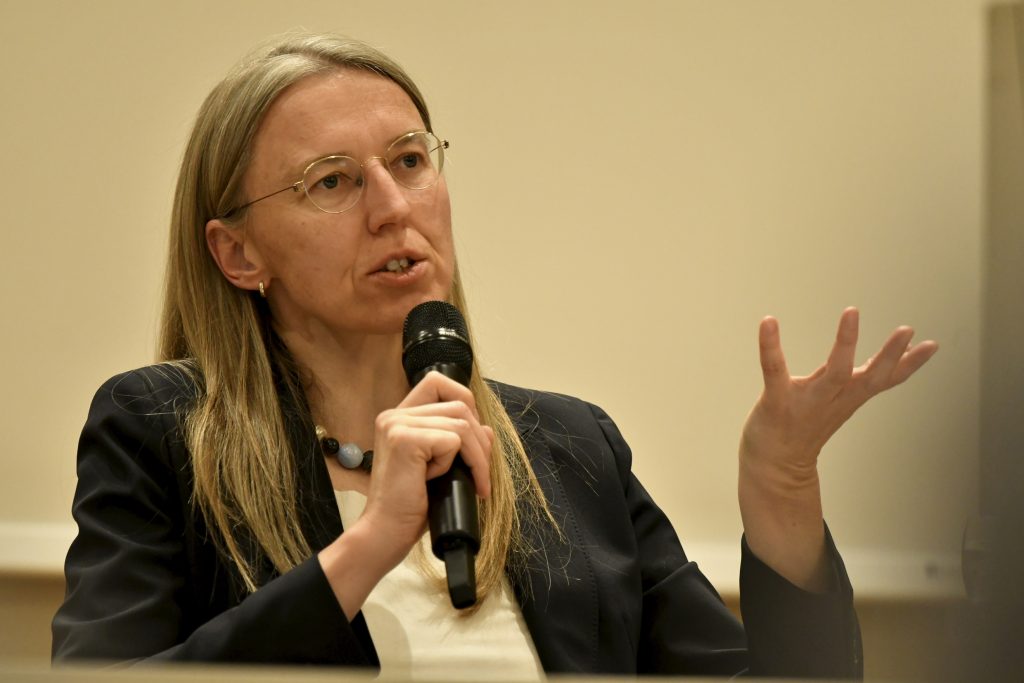 Auer speaking with microphone