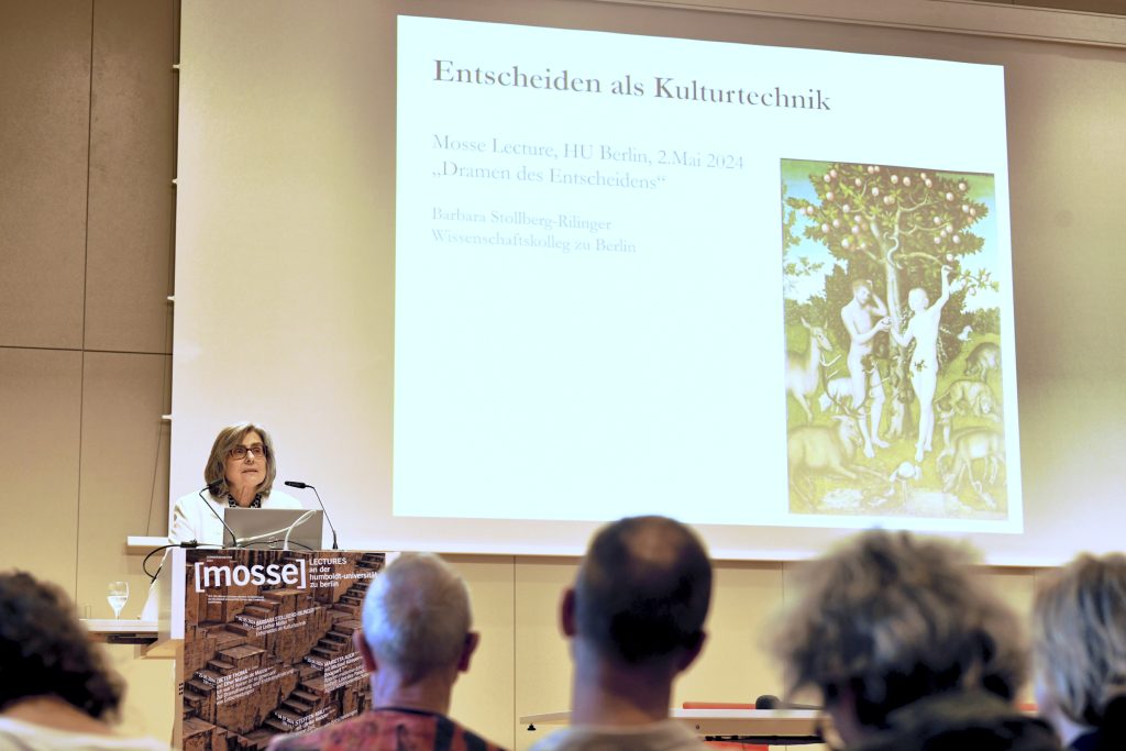 Stollberg-Rilinger during her lecture, with slide of Adam and Eve in the background