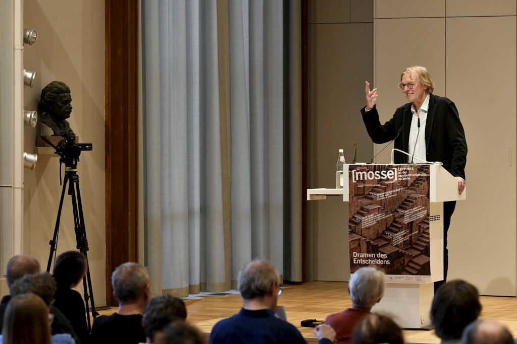The audience listens to Dieter Thomä, who stands at the podium and gestures with his hand