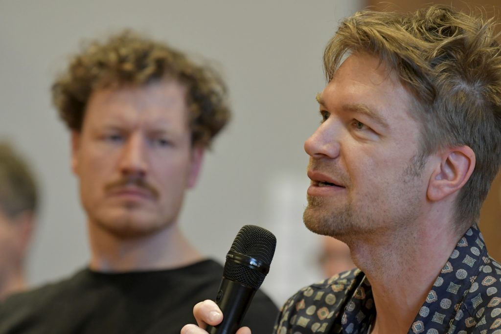 A member of the public asks a question with a microphone in his hand