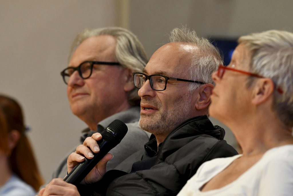 A member of the public asks a question with a microphone in his hand