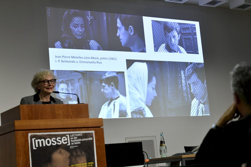 Sigrid Weigel delivering her lecture, with projected images in the background