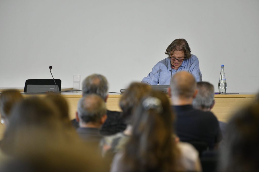 the audience faces Scheuer