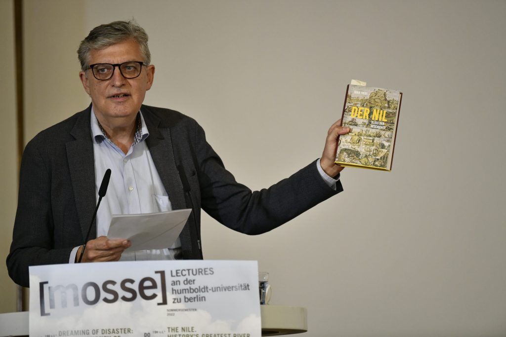 Lothar Müller holds up Tvedt's book at the podium