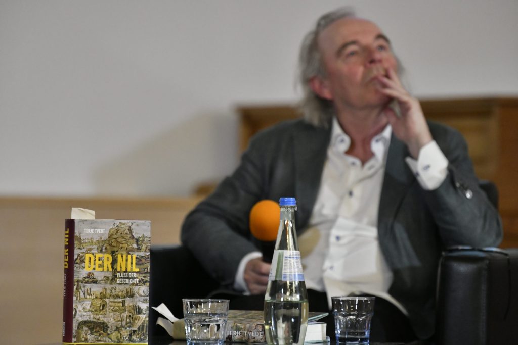 Tvedt reflects, with a copy of his book in the foreground