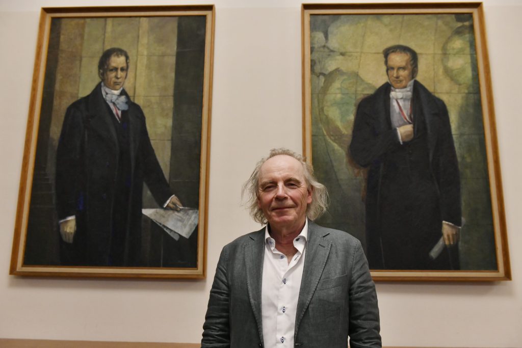 Tvedt poses in front of portraits of the Humboldt brothers