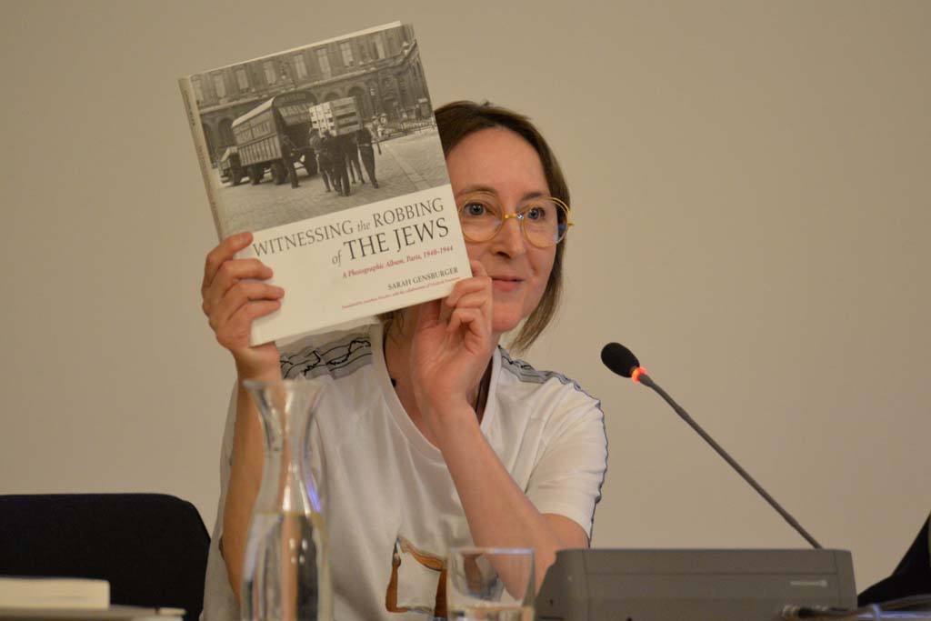 Eichhorn holds up a book titled "Witnessing the Robbing of the Jews"