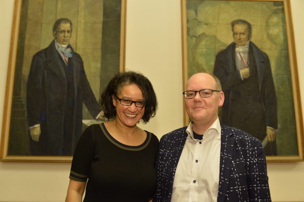 Geimer and de Mazza pose in front of the portraits of the Humboldt brothers