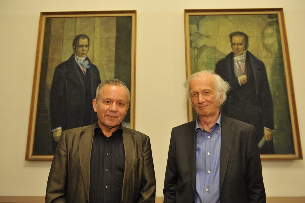 Langewiesche and van-der Boogaart pose in front of the portraits of the Humboldt brothers