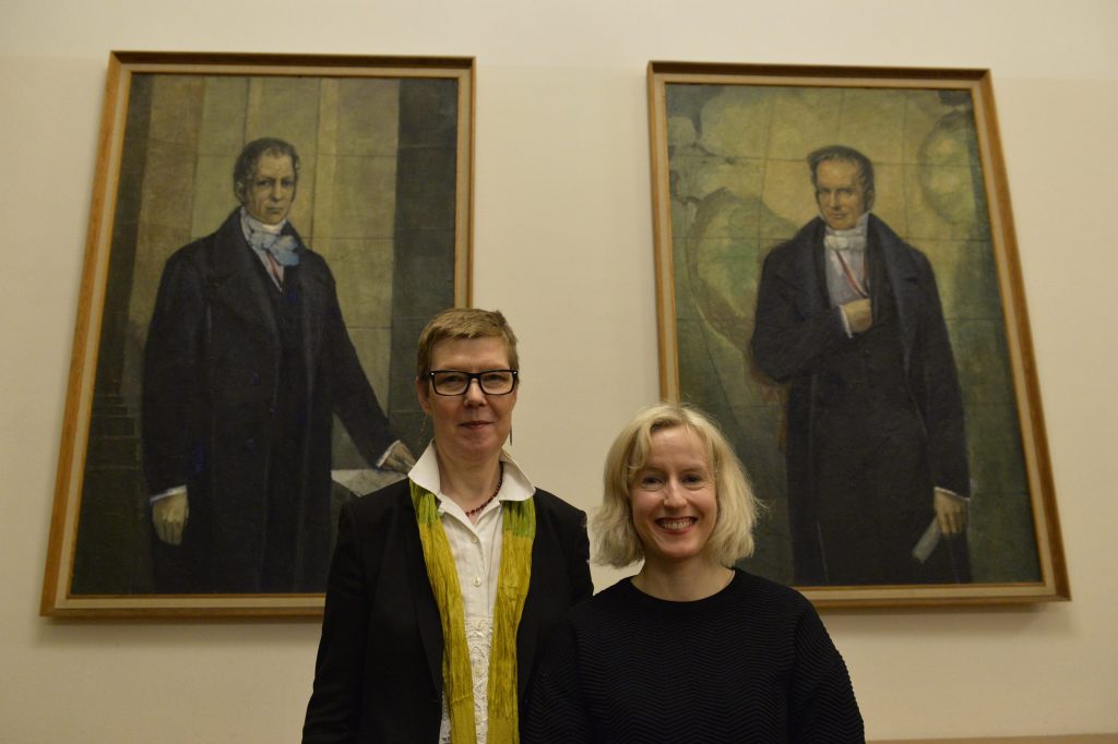 Walshe and Zander pose in front of the portraits of the Humboldt brothers