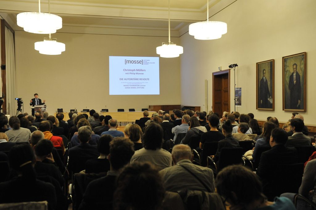 a full audience watches the lecture