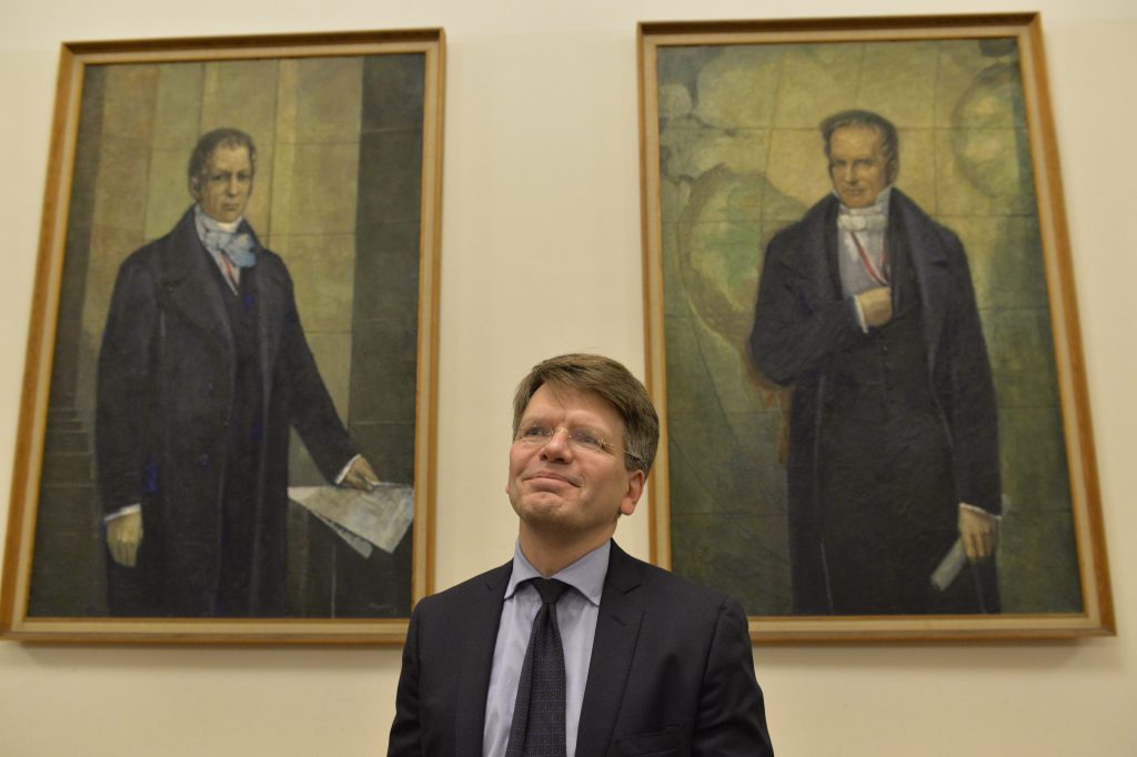 Möllers poses in front of portraits of the Humboldt brothers