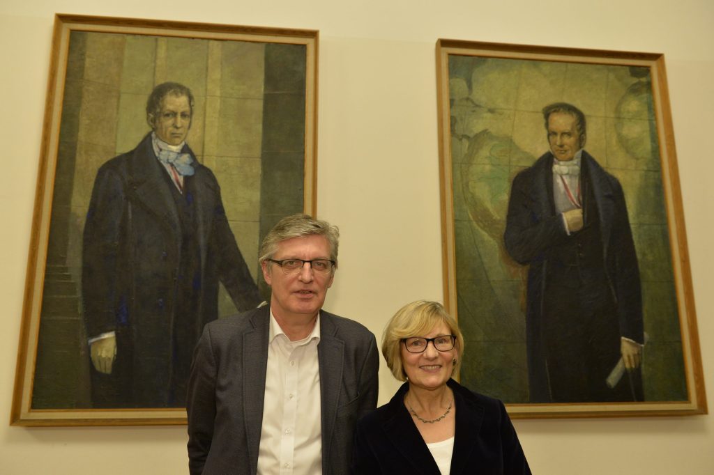 Naumann and Müller pose in front of the portraits of the Humboldt brothers