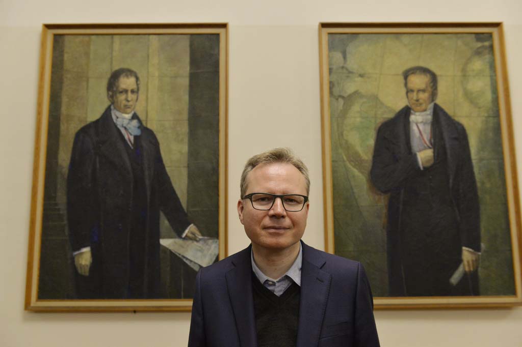 Reckwitz poses in front of the portraits of the Humboldt brothers