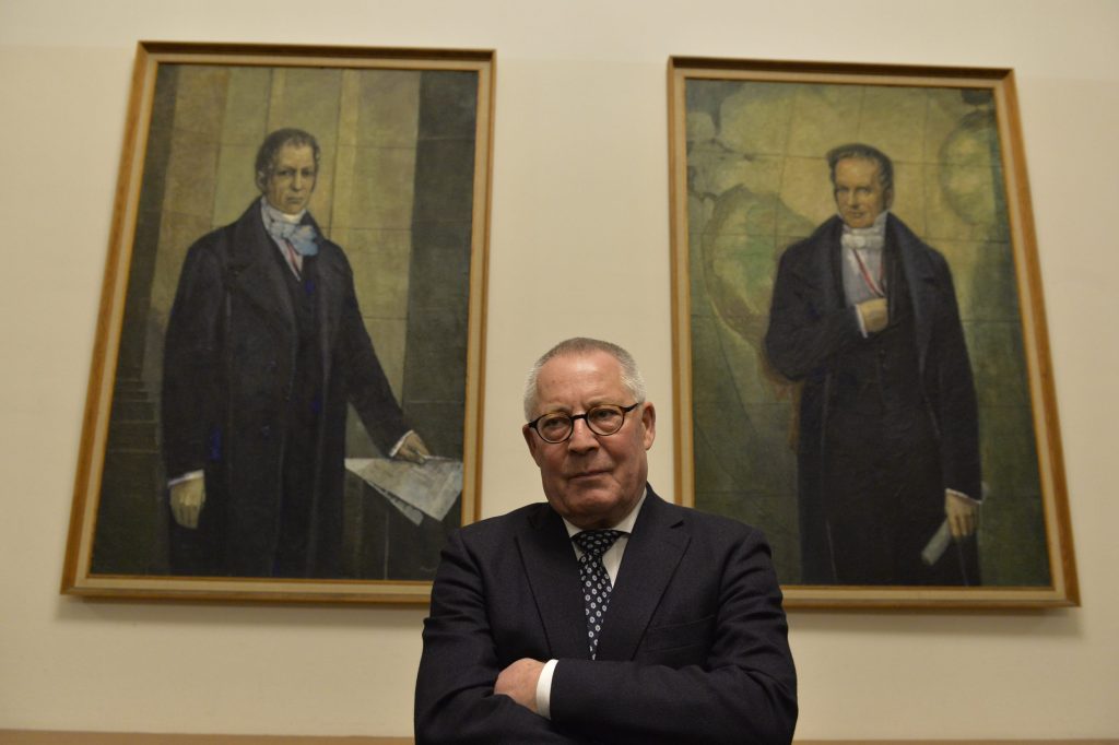 Schlögel poses before the portraits of the Humboldt brothers