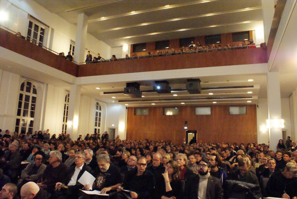 a full audience waits for the lecture