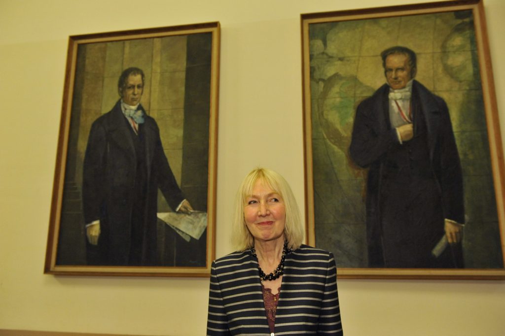 Kronauer poses in front of the portraits of the Humboldt brothers