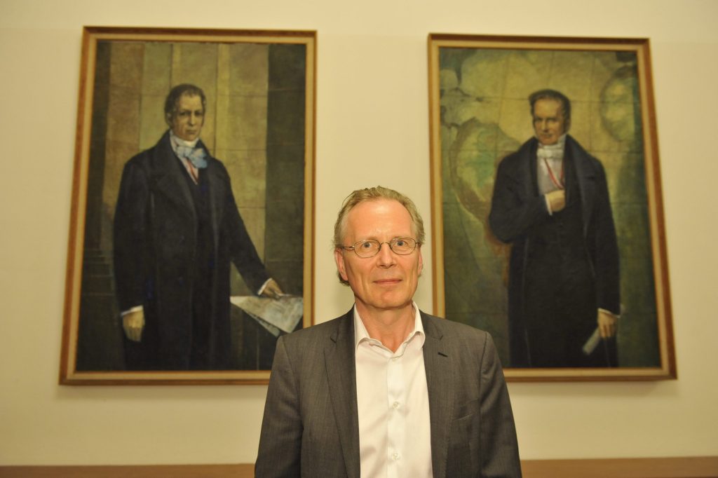 Menke in front of the portraits of the Humboldt brothers