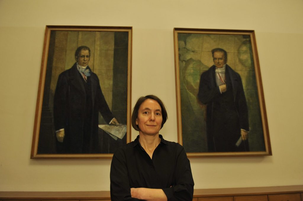 Passig poses before the portraits of the Humboldt brothers