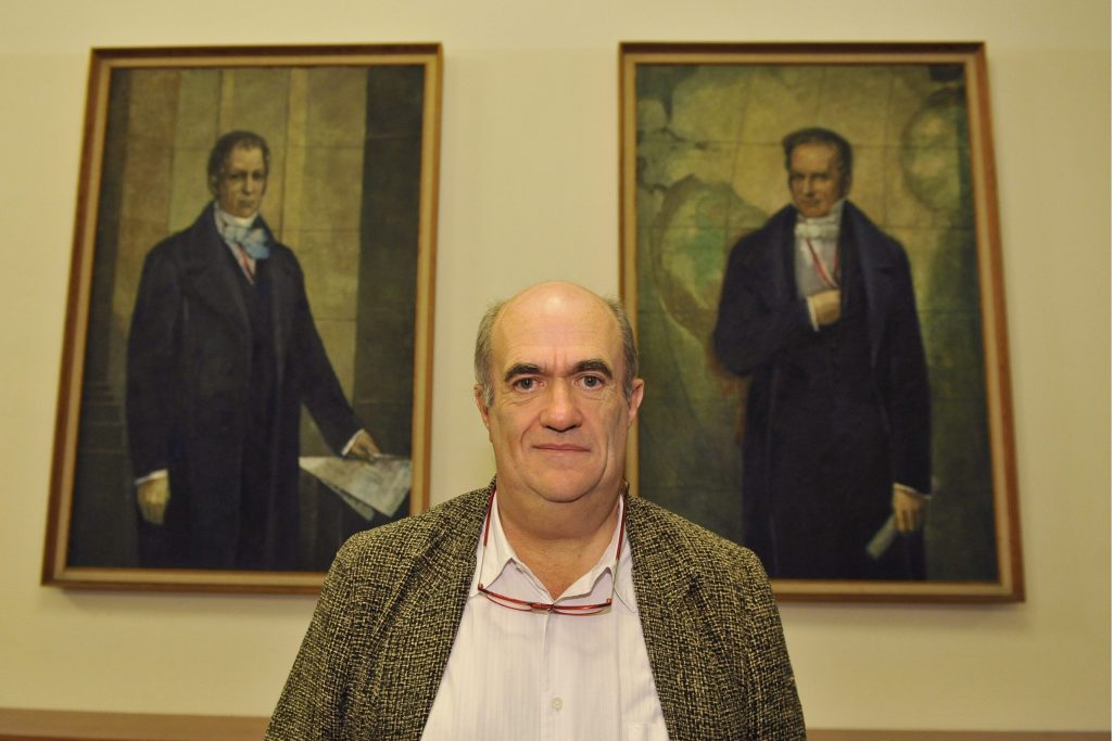 Toibin poses in front of the portraits of the Humboldt brothers