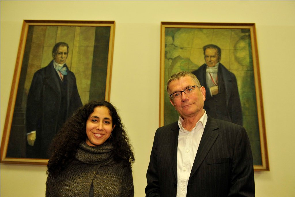 Armbruster and Soliman pose in front of the portraits of the Humboldt brothers