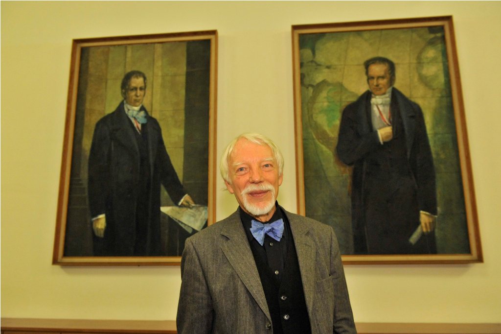 Assmann poses in front of the portraits of the Humboldt brothers