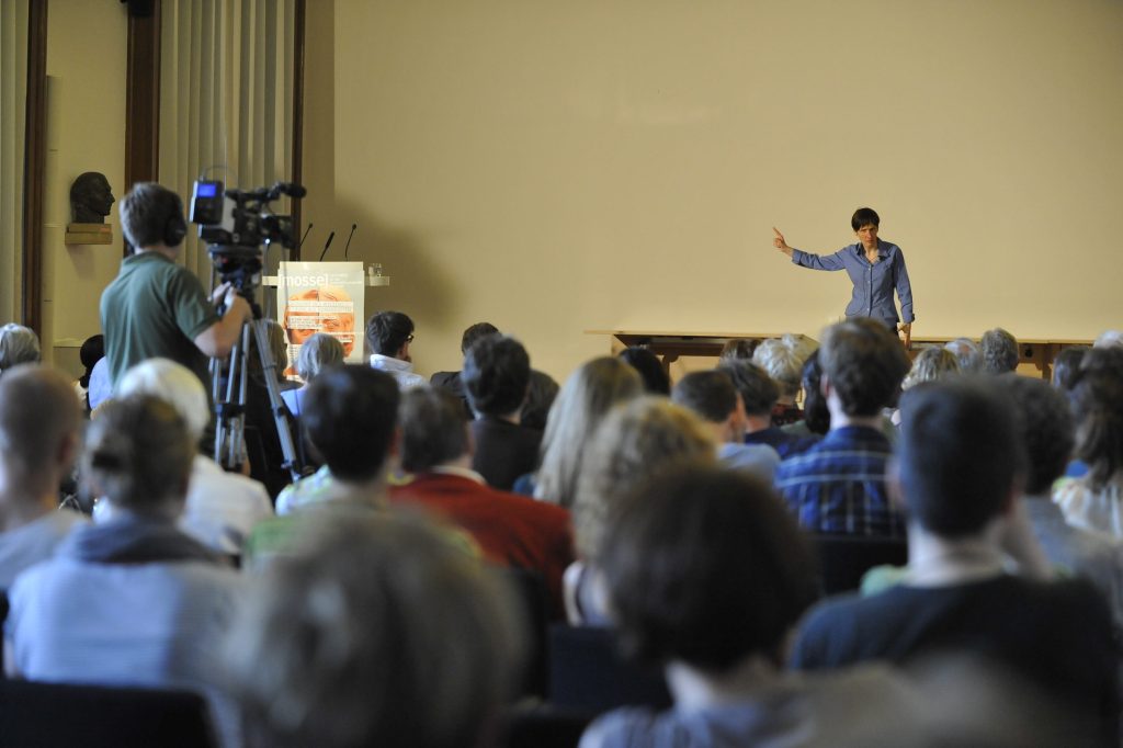 the audience watches Kennedy