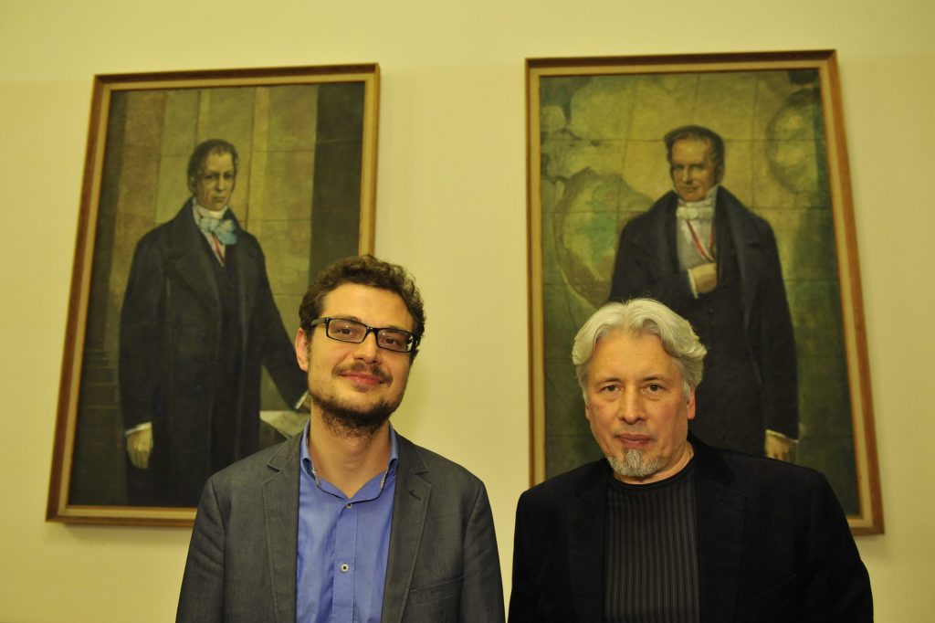 Sorokin and Neshitov pose in front of the portraits of the Humboldt brothers