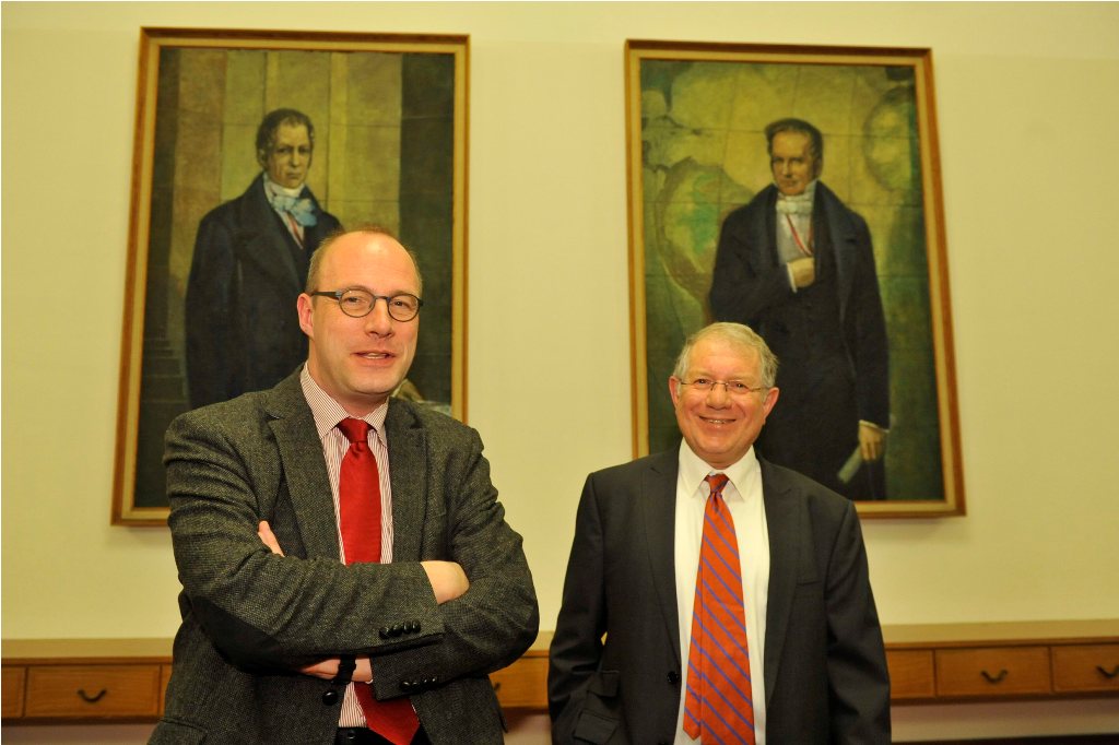 Stroumsa and Markschies pose in front of the portraits of the Humboldt brothers