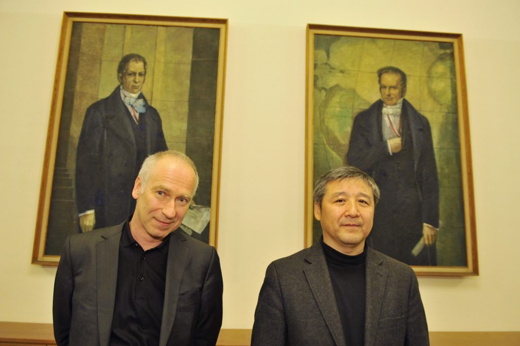 Hui and Vogl pose before the portraits of the Humboldt brothers