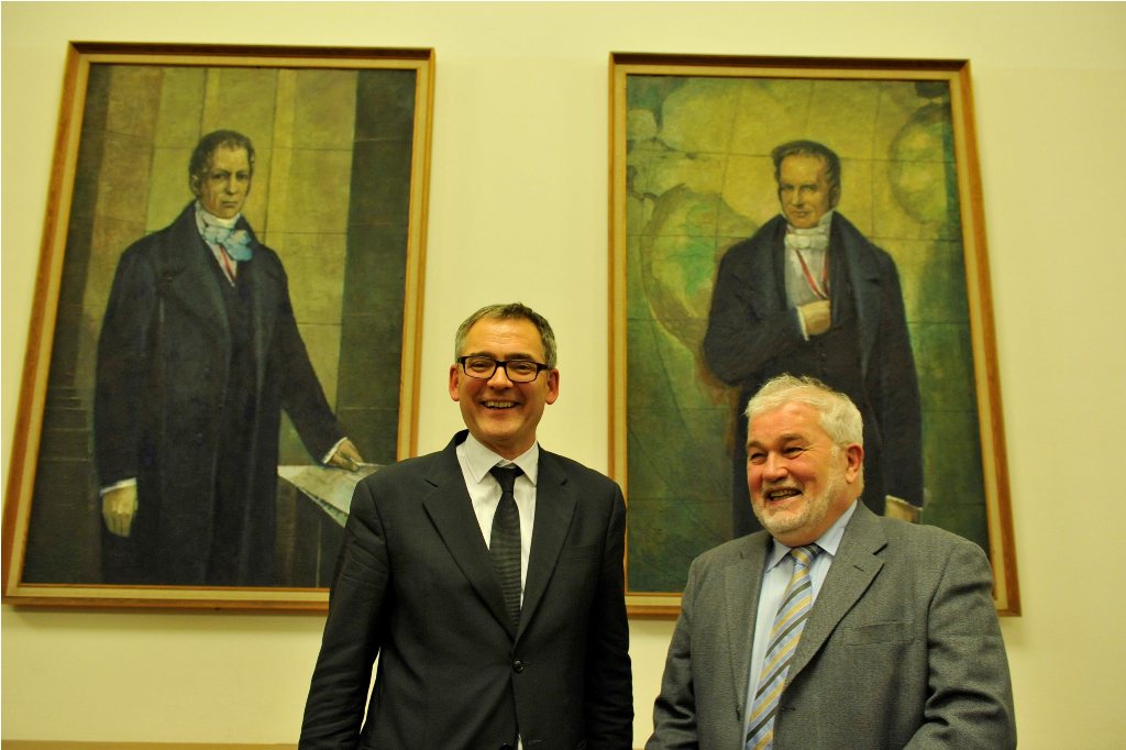 Gosenwinkel and Kocka pose in front of the portraits of the Humboldt brothers