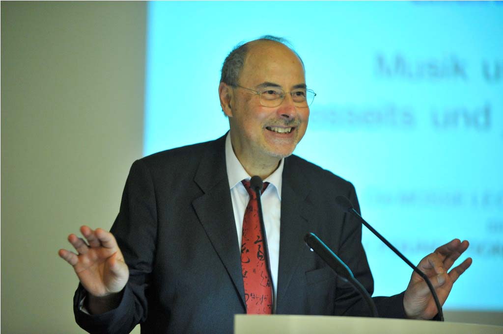 a smiling Danuser lectures from the podium